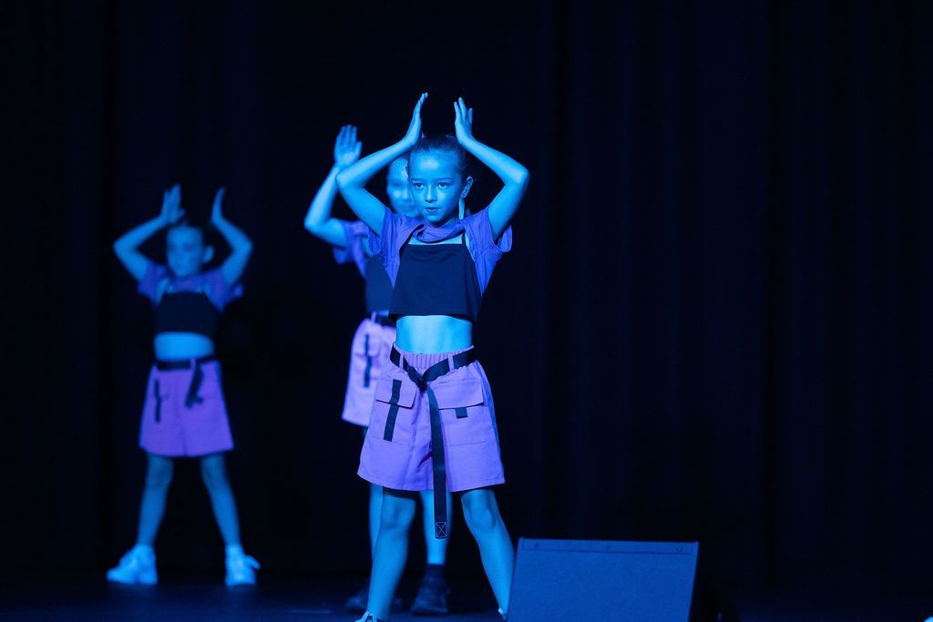 Girl Sticking Tongue Out in Camouflage Overalls Onstage — Mc Dynamic Studio in Currajong, QLD