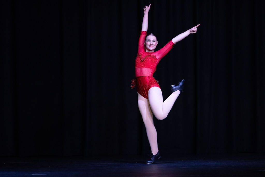 Dancer in Black Sequined Costume Leaps in the Air With One Arm Raised — Mc Dynamic Studio in Currajong, QLD