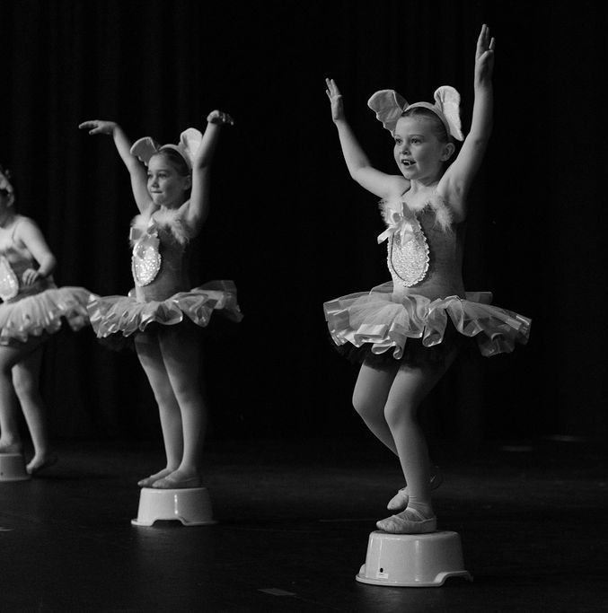 Young Dancer on Stage in Pink Floral Leotard and Tights, Arms Raised, Performing — Mc Dynamic Studio in Currajong, QLD