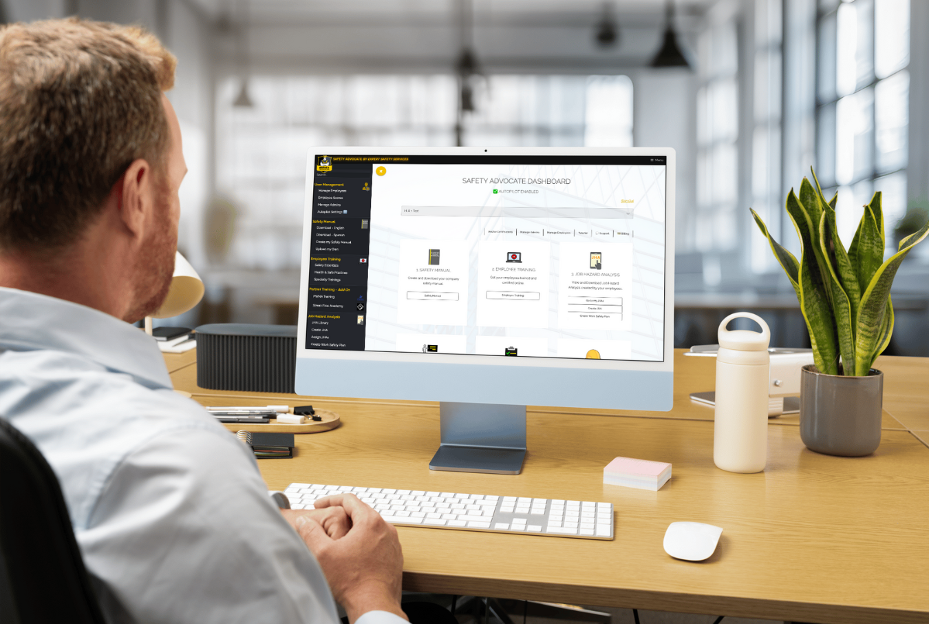 A man is sitting at a desk using a computer.