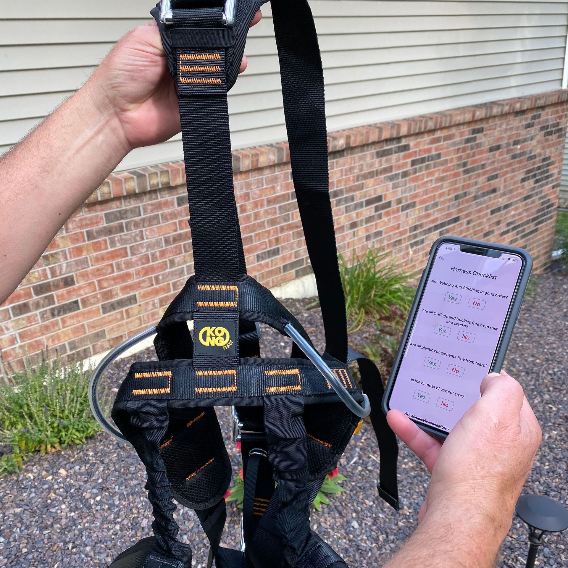 A person holding a cell phone next to a harness