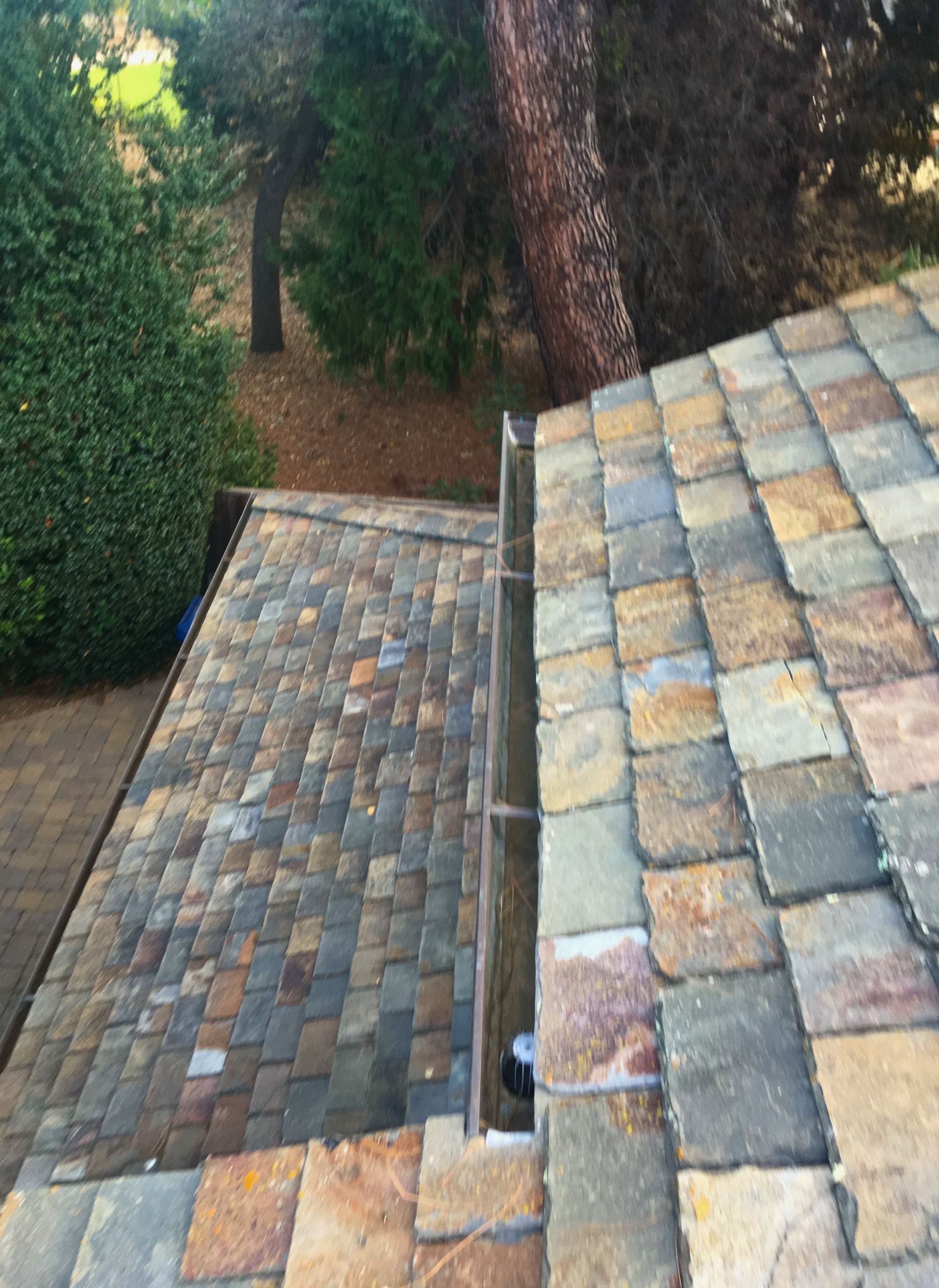 A drain on the side of a brick roof