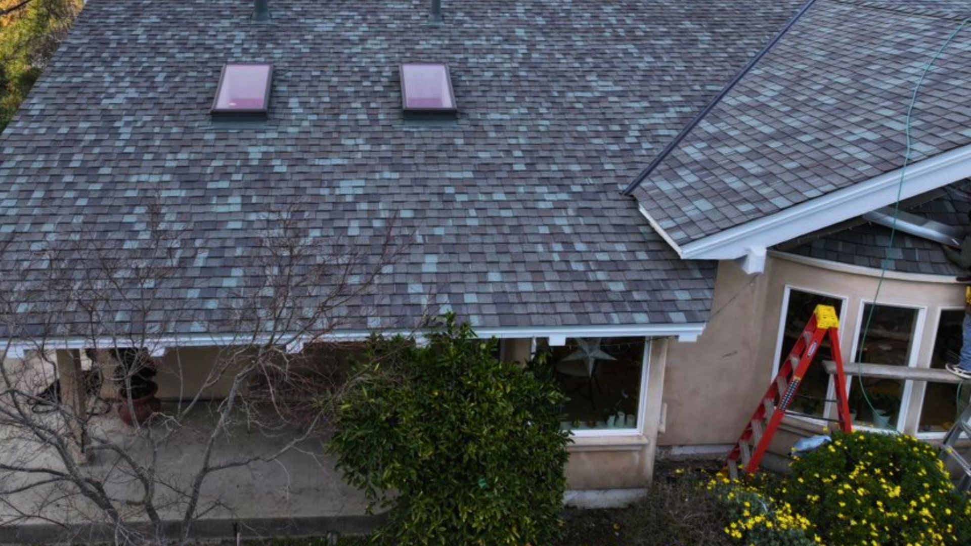 An aerial view of a house with a ladder in front of it.