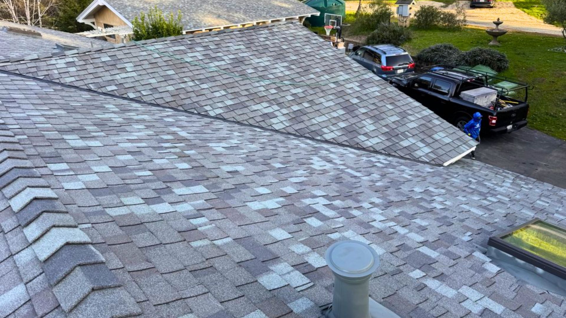The roof of a house with a truck parked in the driveway.