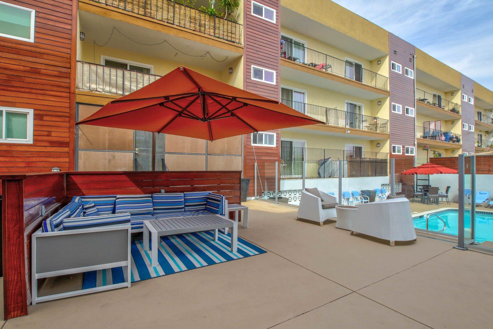 outdoor pool area with lawn chairs and umbrellas