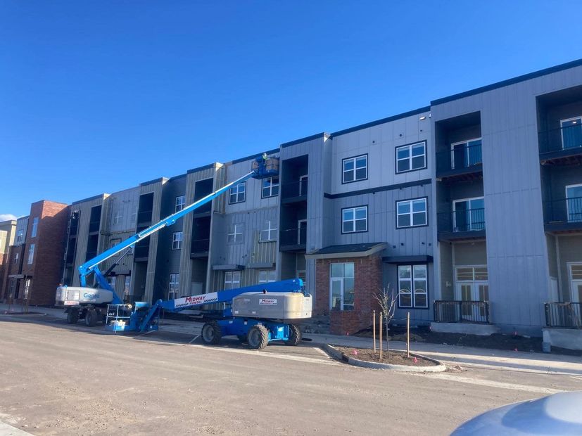 A large apartment building under construction with a crane in front of it.