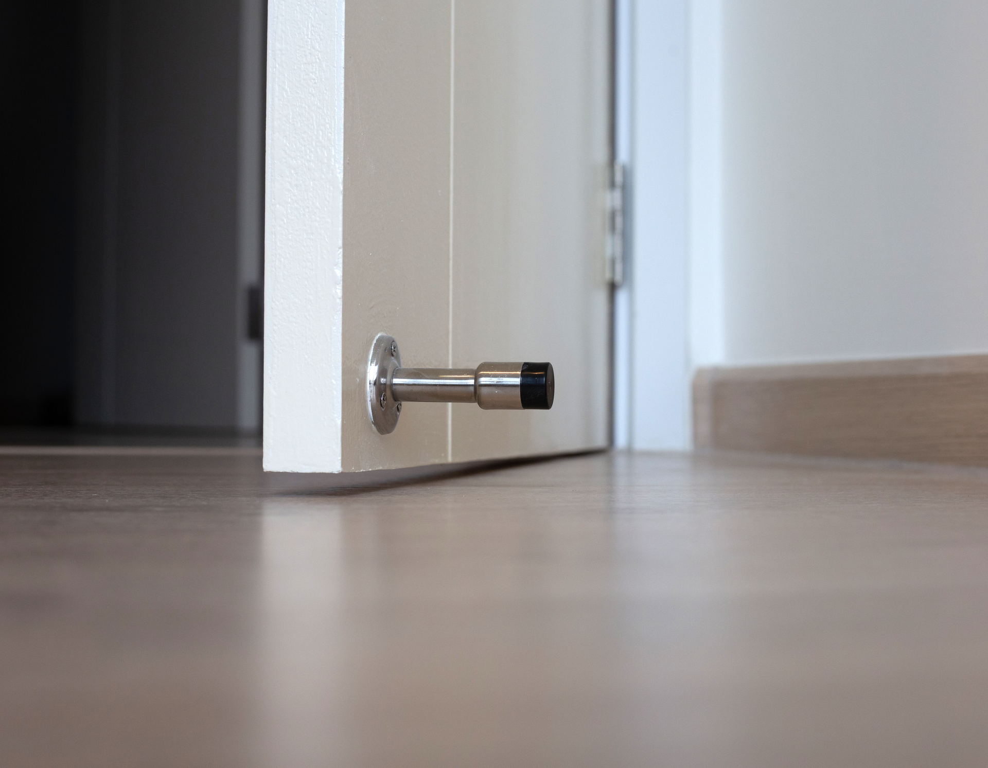 A door stop is attached to the side of a door.