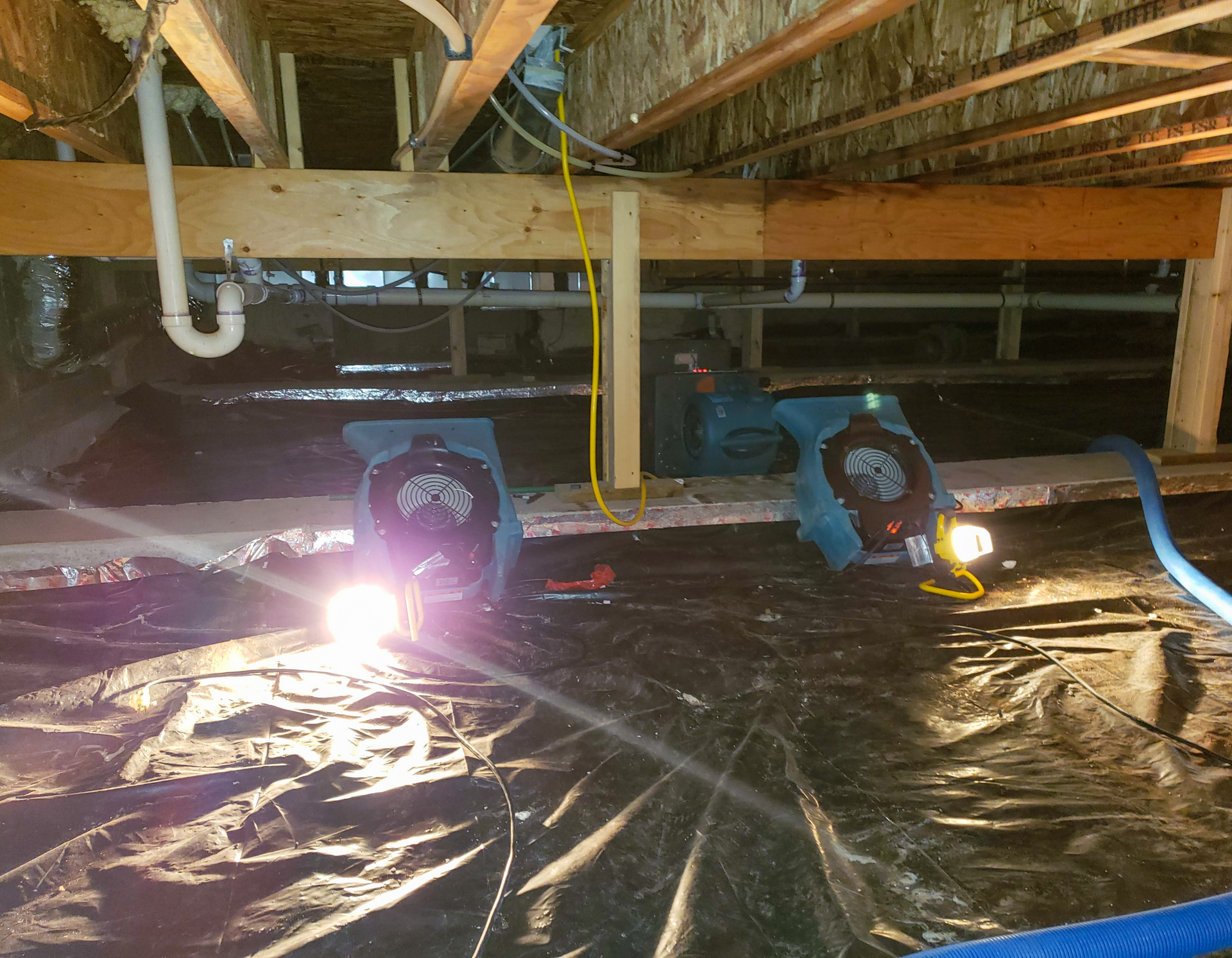There are two fans in the ceiling of a basement.
