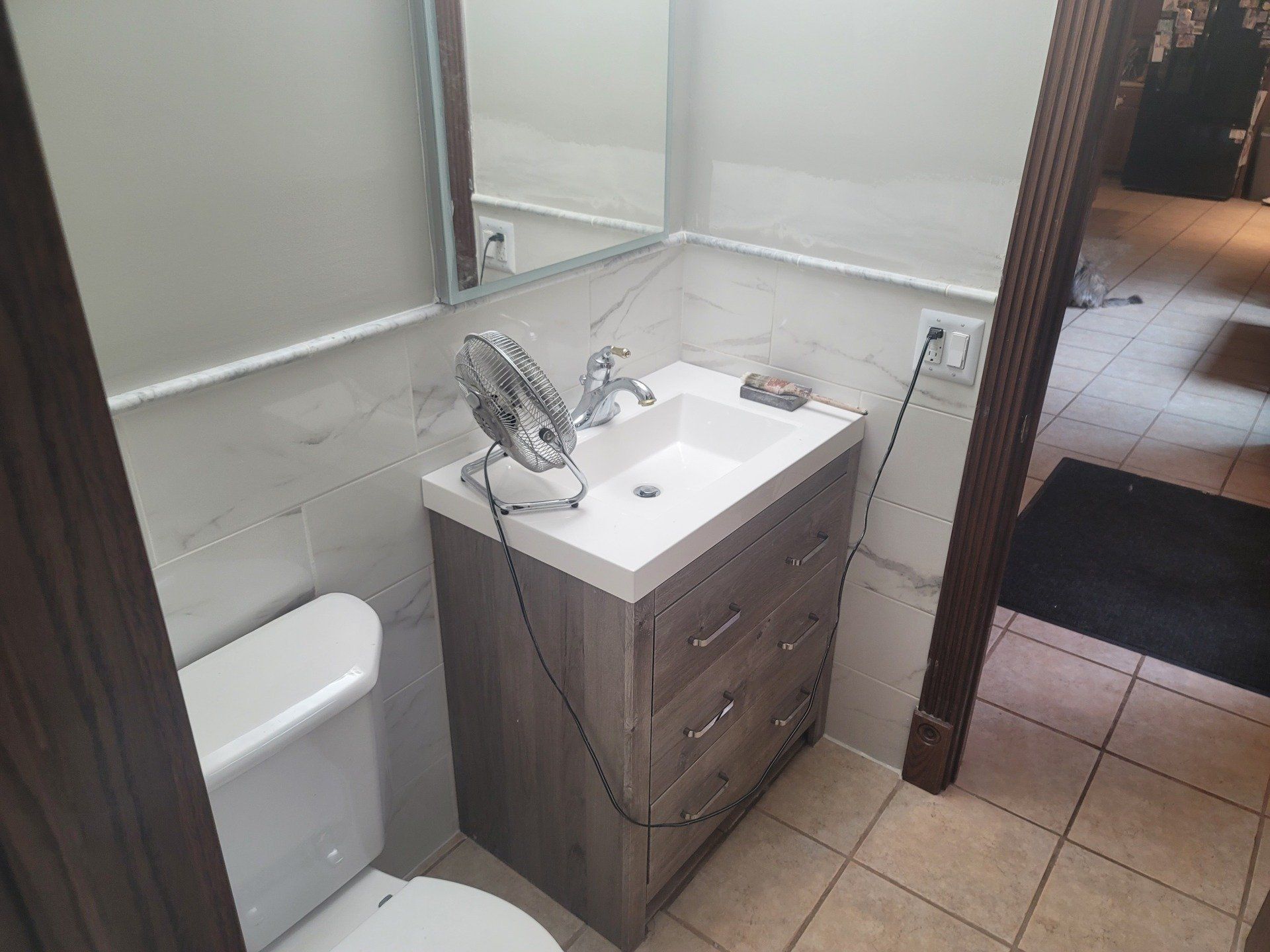 A bathroom with a sink , toilet and mirror.