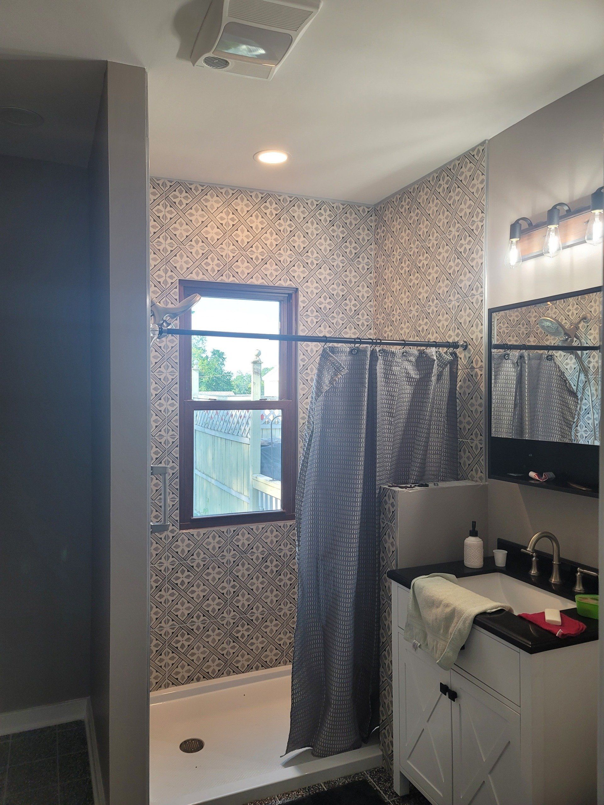 A bathroom with a sink a shower and a window