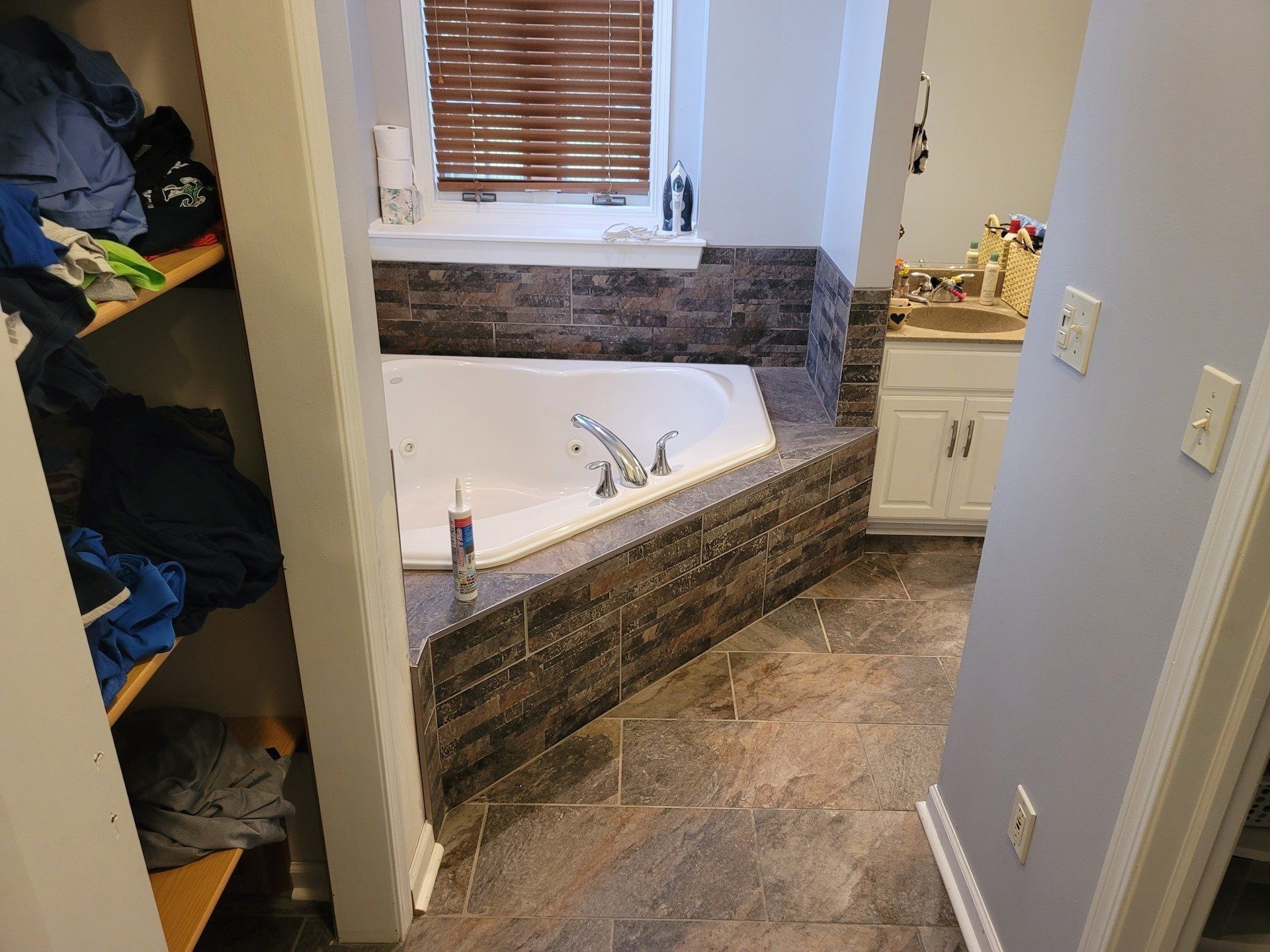 A bathroom with a jacuzzi tub and a window.