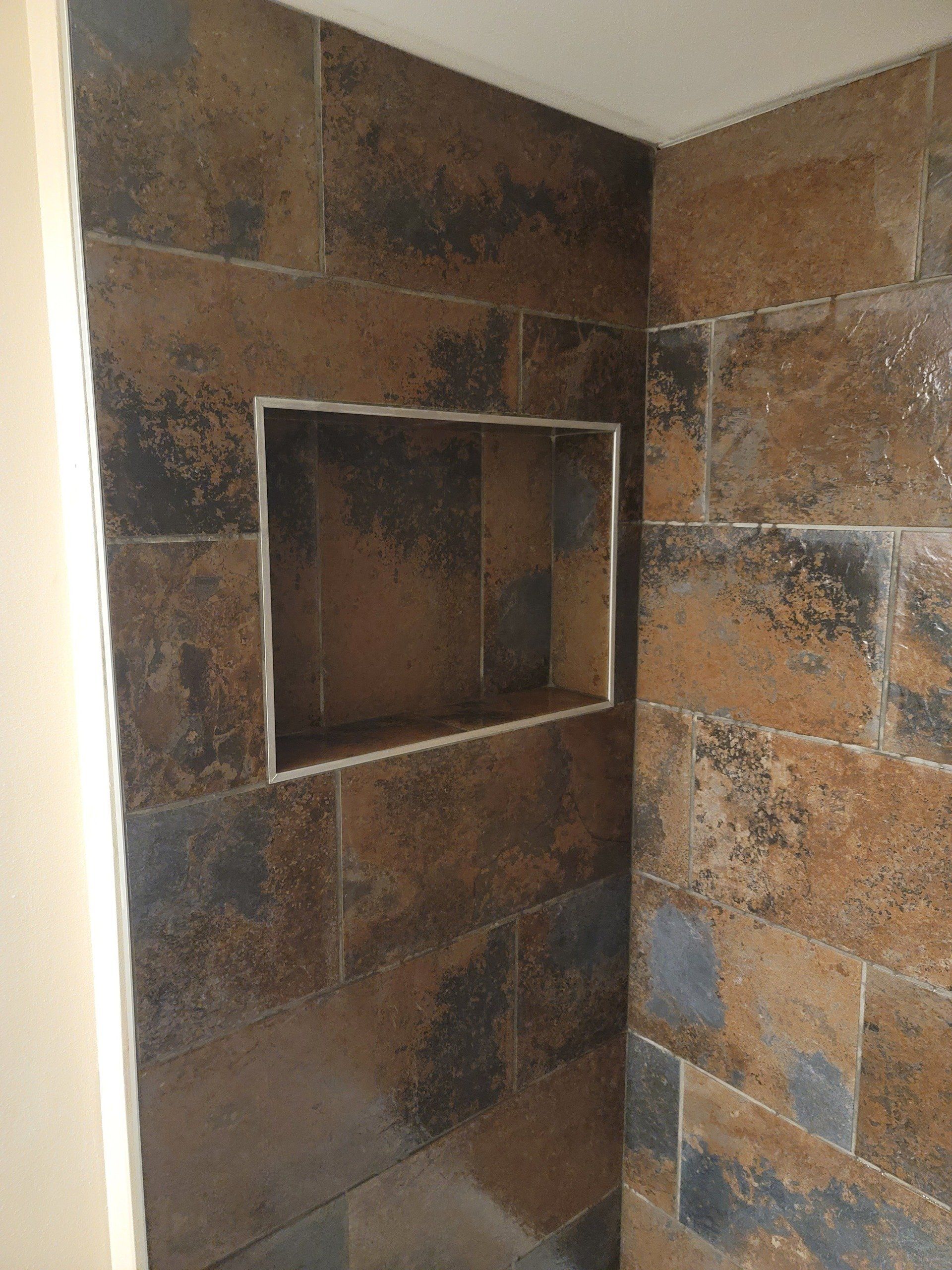 There is a niche in the wall of the shower.