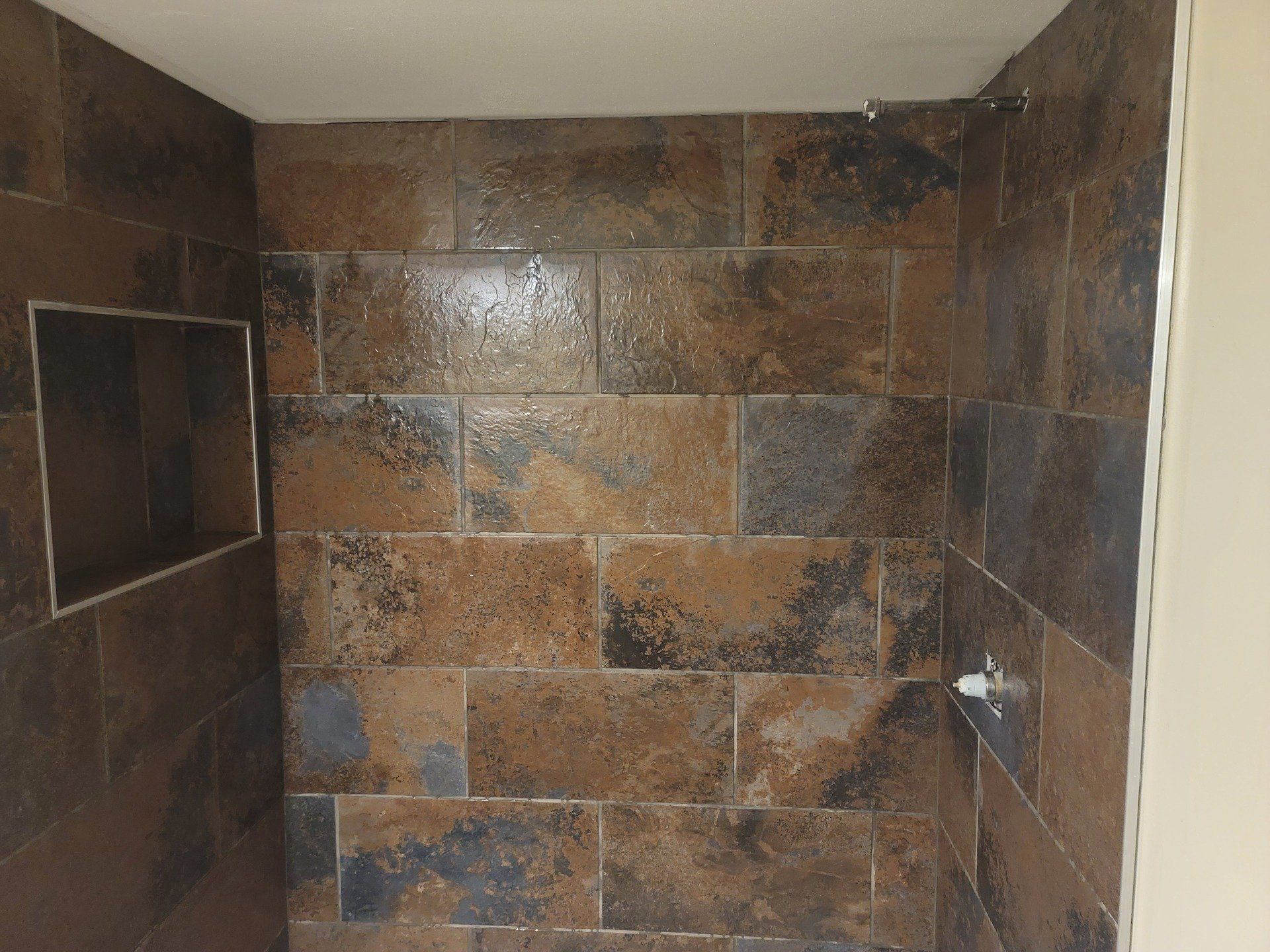 A bathroom with brown tiles on the walls