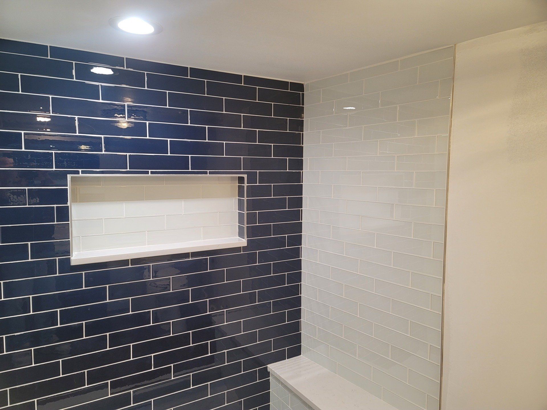 A bathroom with black and white tiles and a shower stall