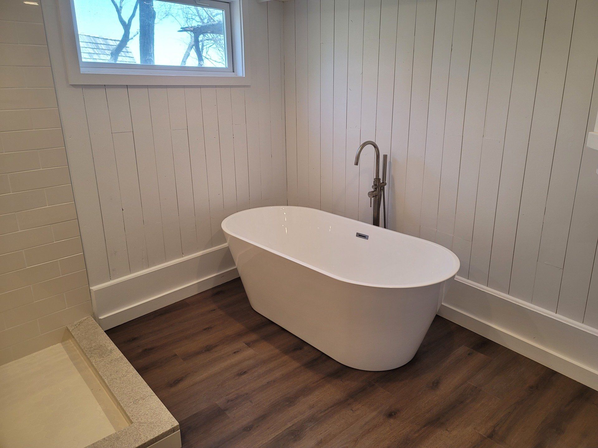 A bathroom with a bathtub and a shower.