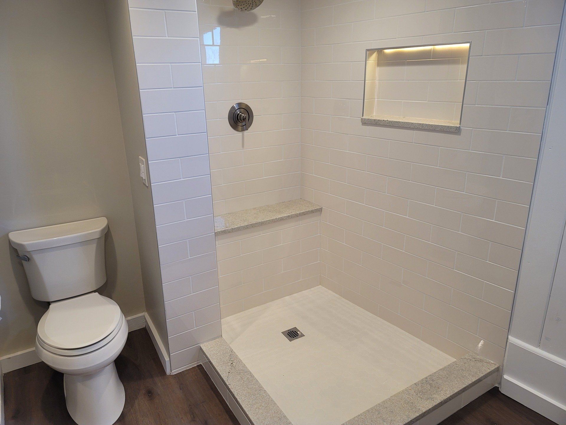 A bathroom with a toilet and a walk in shower.