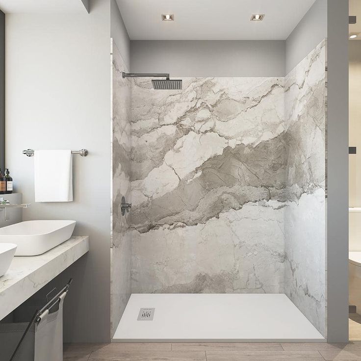 Modern bathroom with a marble-patterned shower, white basin, and a towel rack.