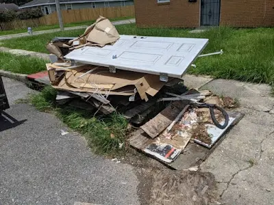 A white door is sitting on top of a pile of cardboard.