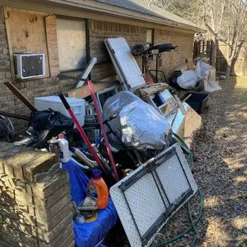 A pile of trash is sitting in front of a house.
