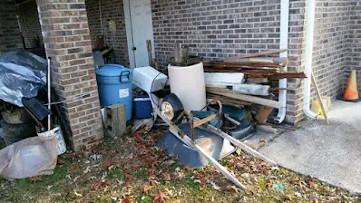 A pile of trash is sitting in front of a brick building.