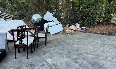 A patio with a table and chairs and a pile of trash.