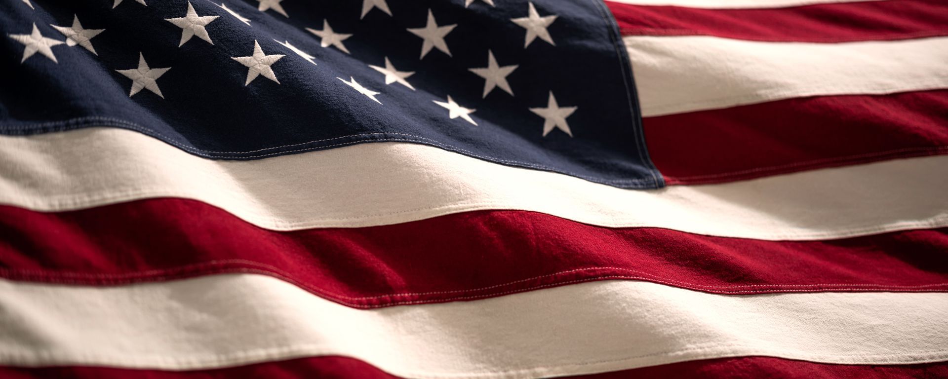 A close up of an american flag waving in the wind