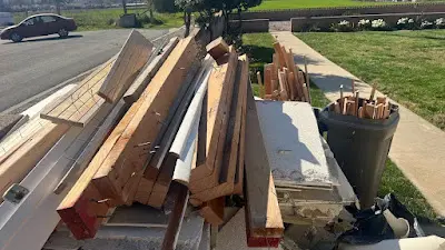A pile of wood is sitting on the side of the road.
