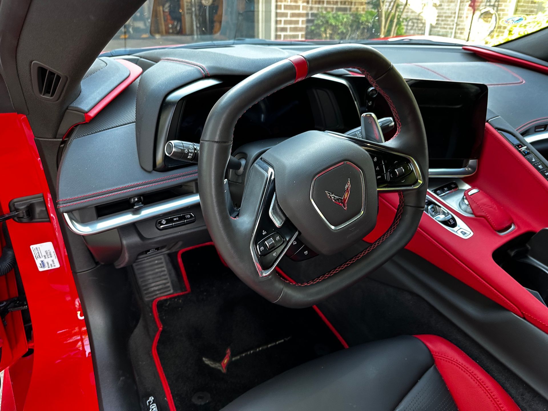 The interior of a red sports car with a black steering wheel