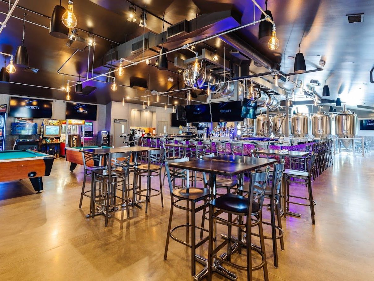 A large room filled with tables and chairs and pool tables.