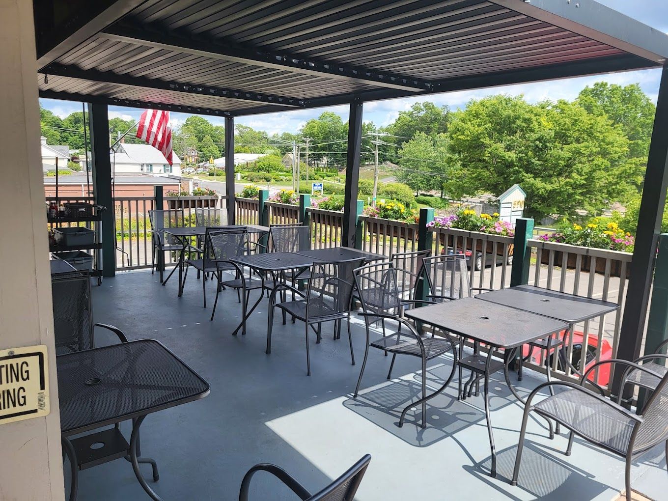 A patio with tables and chairs under a canopy.