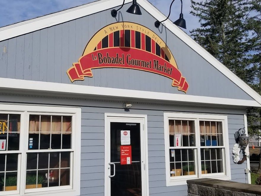 A gray building with a sign that says open on it