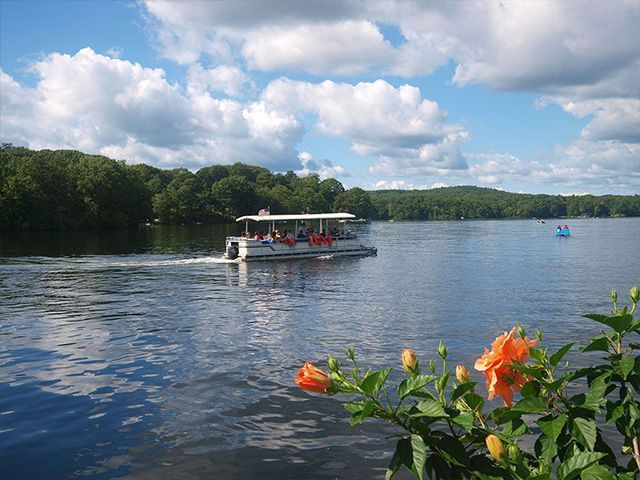 A boat with people on it is floating on a lake