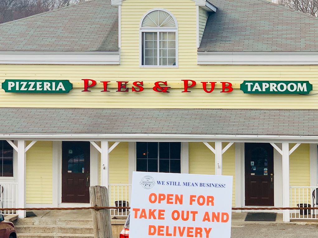 A yellow building with a sign that says open for take out and delivery