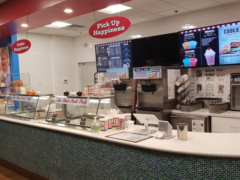 A restaurant with a counter and a sign