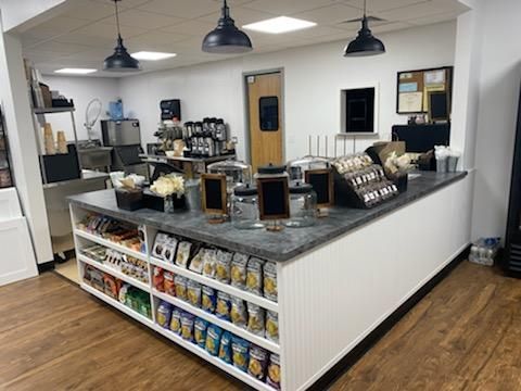 A kitchen with a counter and shelves filled with snacks.
