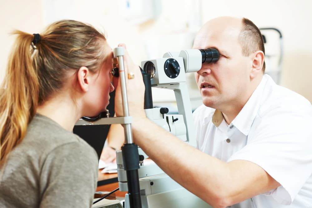 An Optometrist Examines a Young Woman's Eyes Using a Slit Lamp Microscope in a Clinical Setting