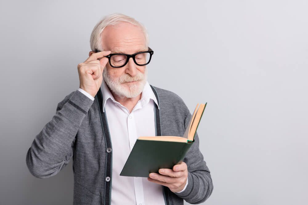 Senior Man Reading Book — Your Ophthalmologist in Townsville, QLD