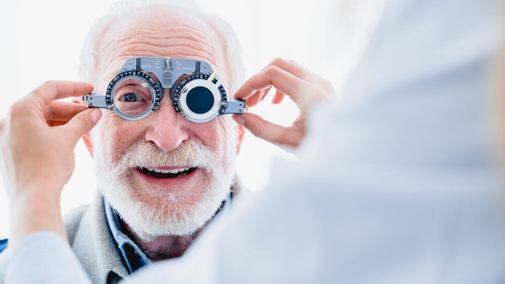 Testing Lenses On Older Man — Your Ophthalmologist in Townsville, QLD