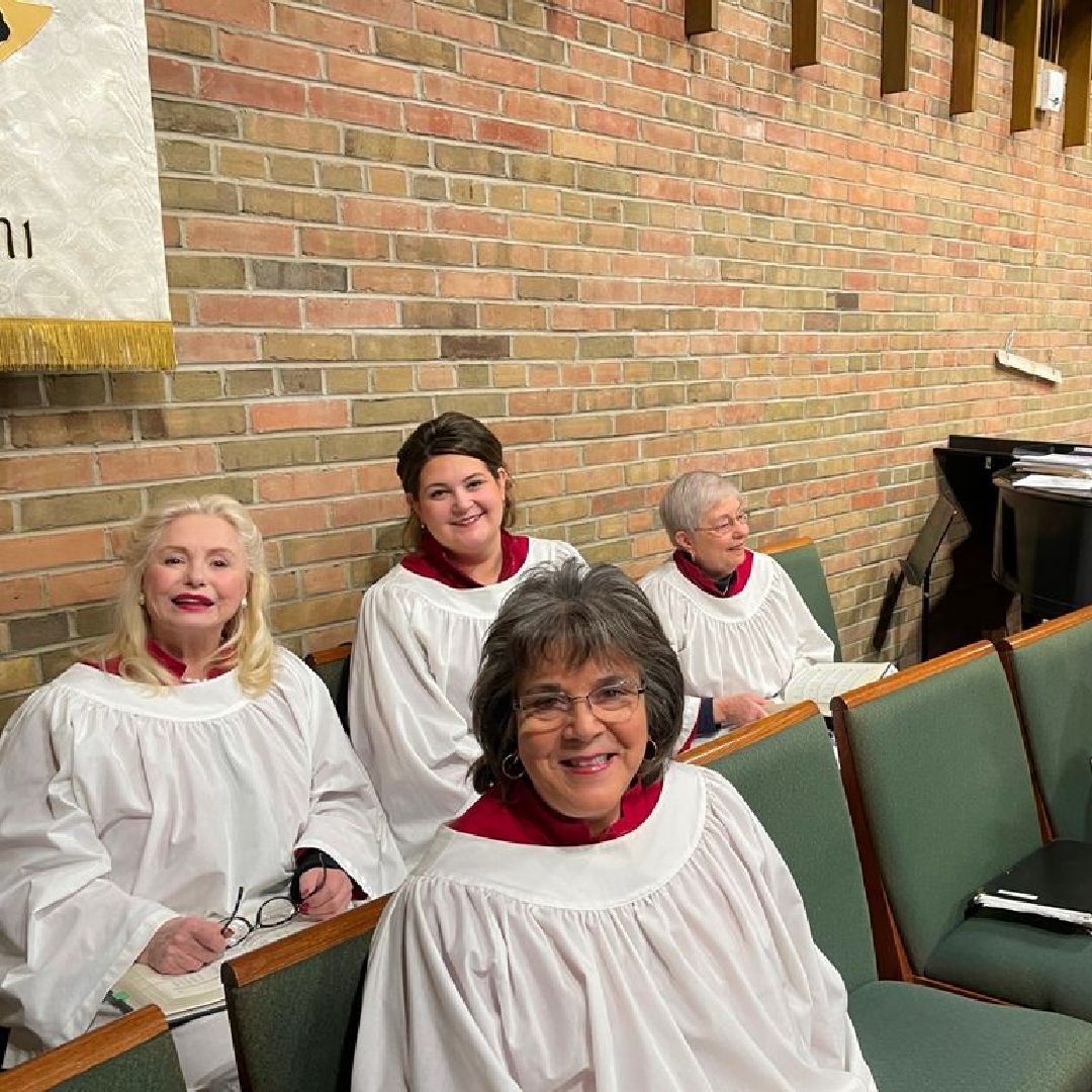 church choir in robes, 3 female members smiling. 