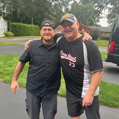 two men are posing for a picture and one has the number 23 on his shirt