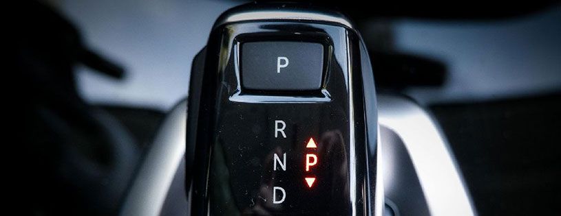 A close up of a car shifter with the letters r n p and d visible