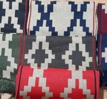Un grupo de almohadas con un patrón están colocadas una encima de otra sobre una mesa.