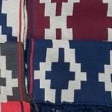 Un primer plano de una manta roja, blanca y azul con un patrón geométrico.