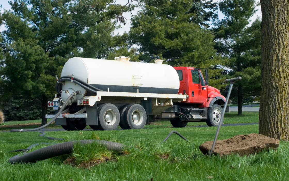 A large septic truck pumping a septic system in Coos Bay.