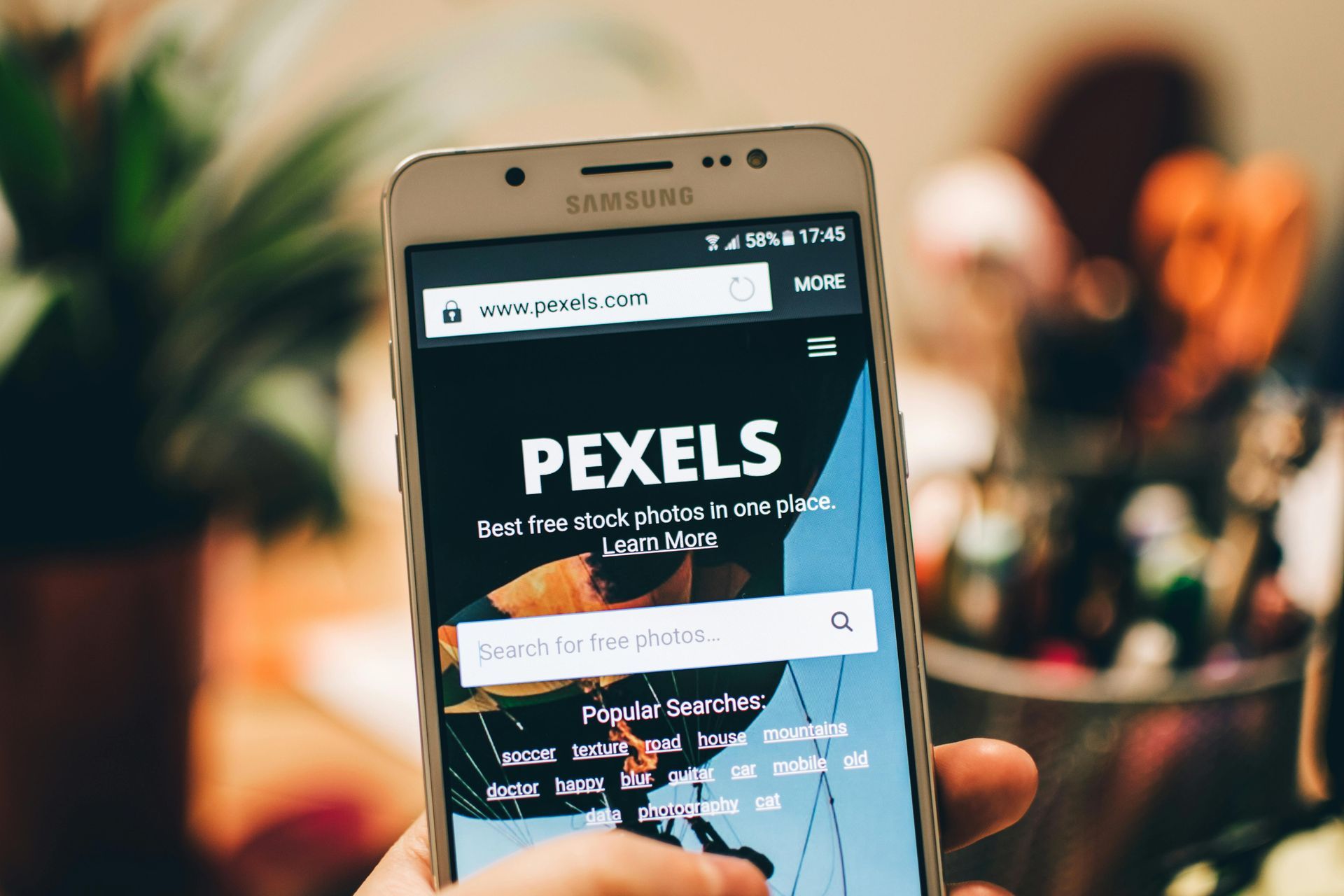 A person is holding a cell phone with the word pexels on the screen.
