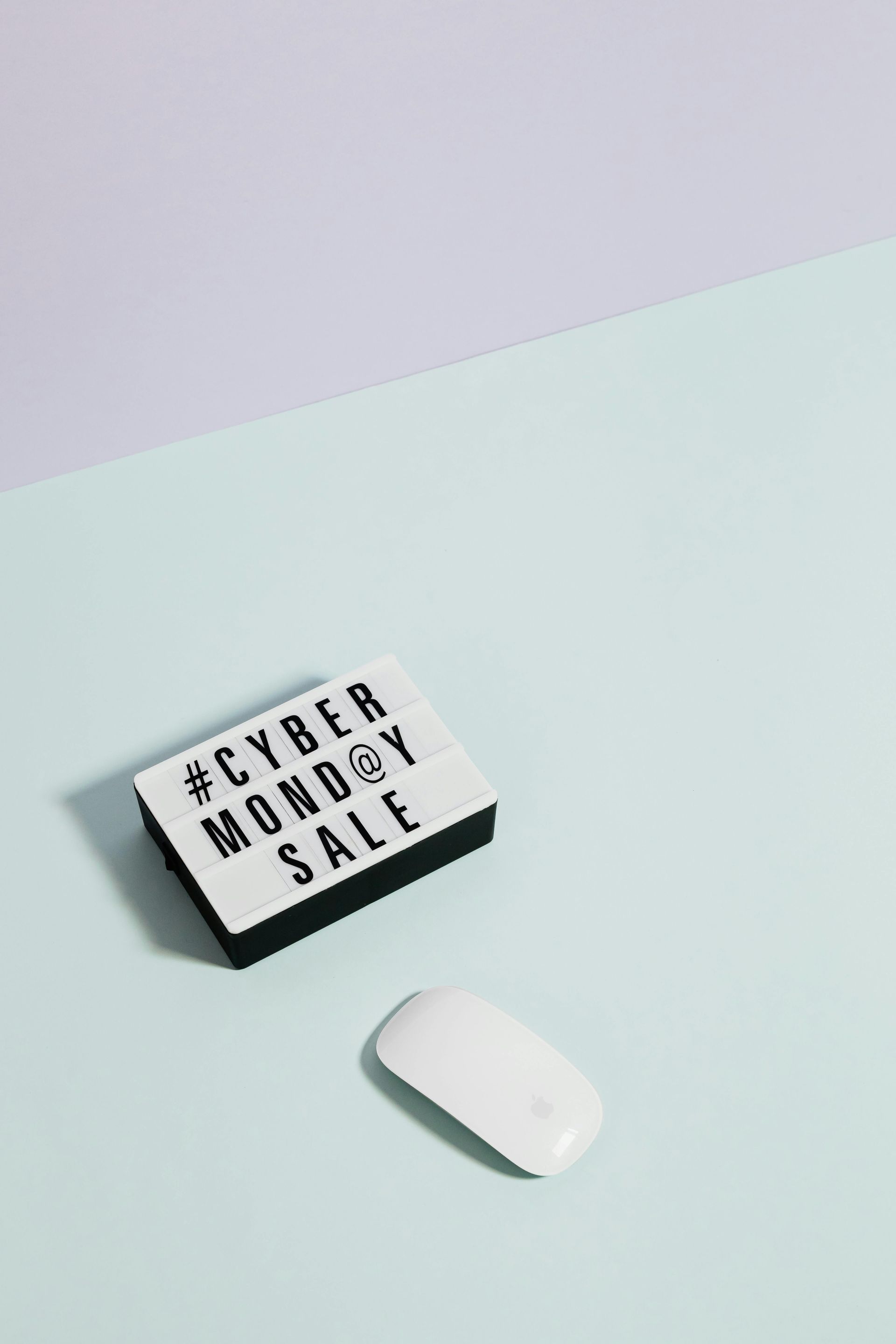 A computer mouse sits next to a sign that says cyber monday sale