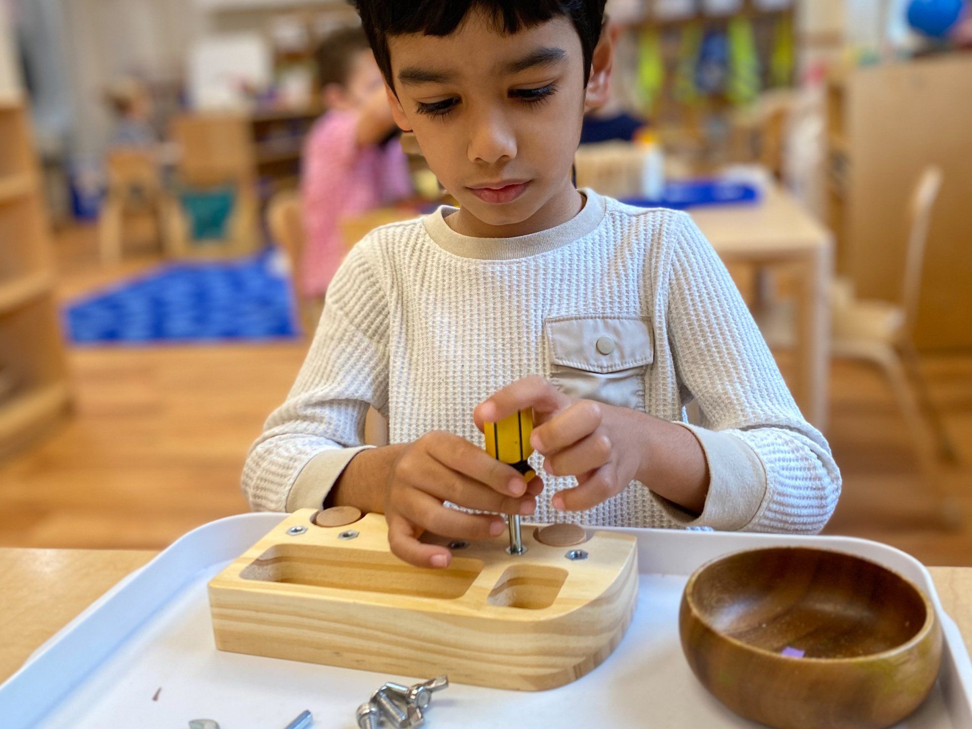 Montessori Child working with practical life materials