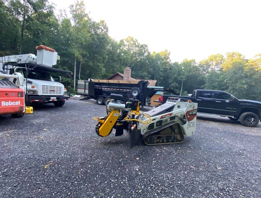 A tractor is parked in a gravel lot next to a truck.