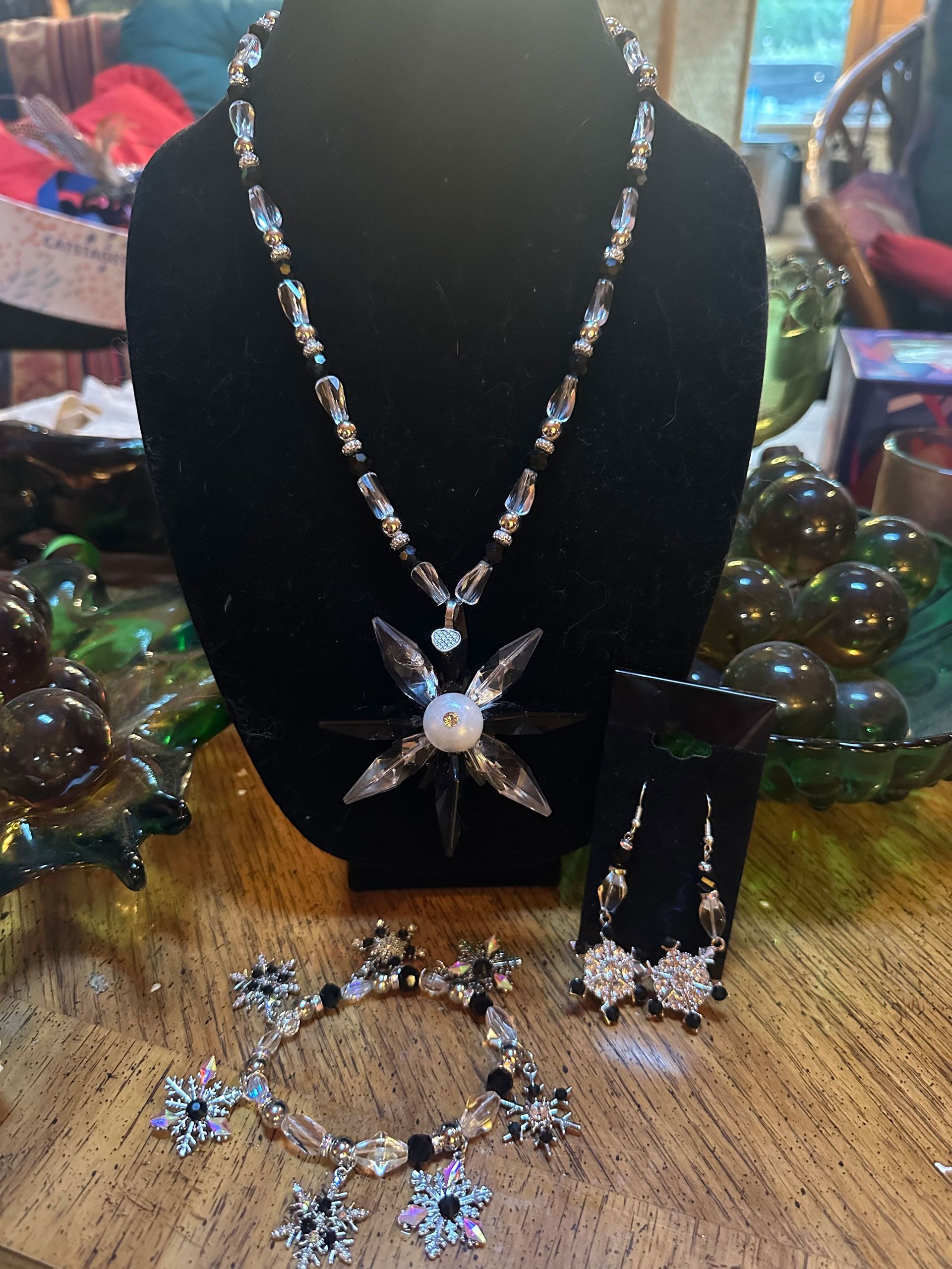 Jewelry set: necklace, bracelet, earrings with black, white, and clear crystals, displayed on a table.