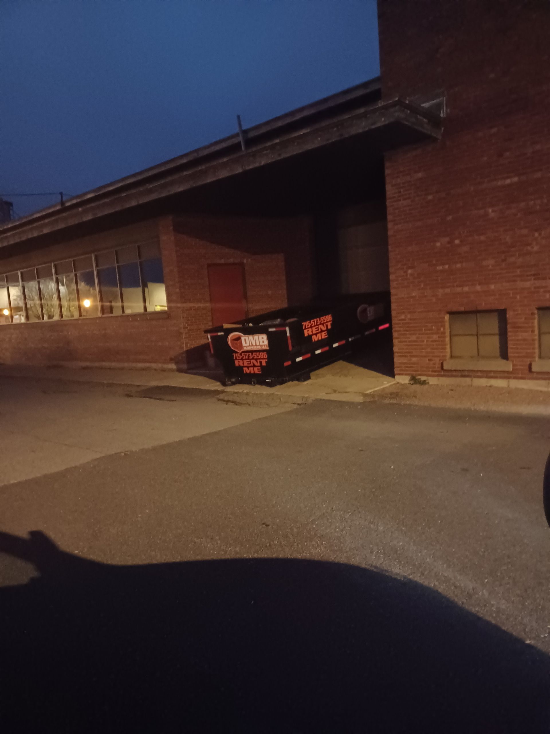 A tow truck is parked in front of a brick building